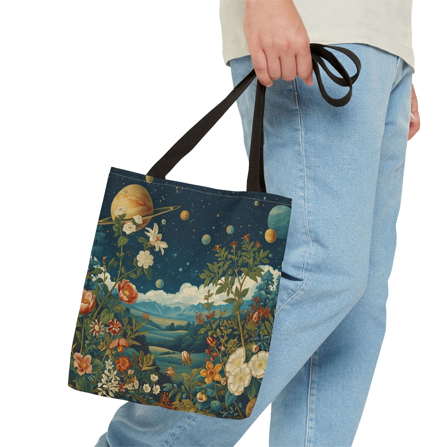 Man carrying a canvas tote bag printed with a surreal landscape design of nature and planets in space