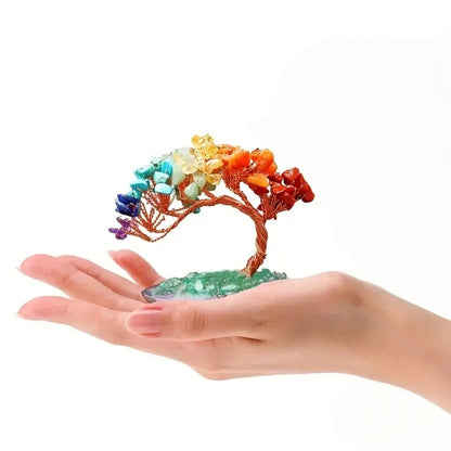 Colorful crystal tree on a hand against a white background