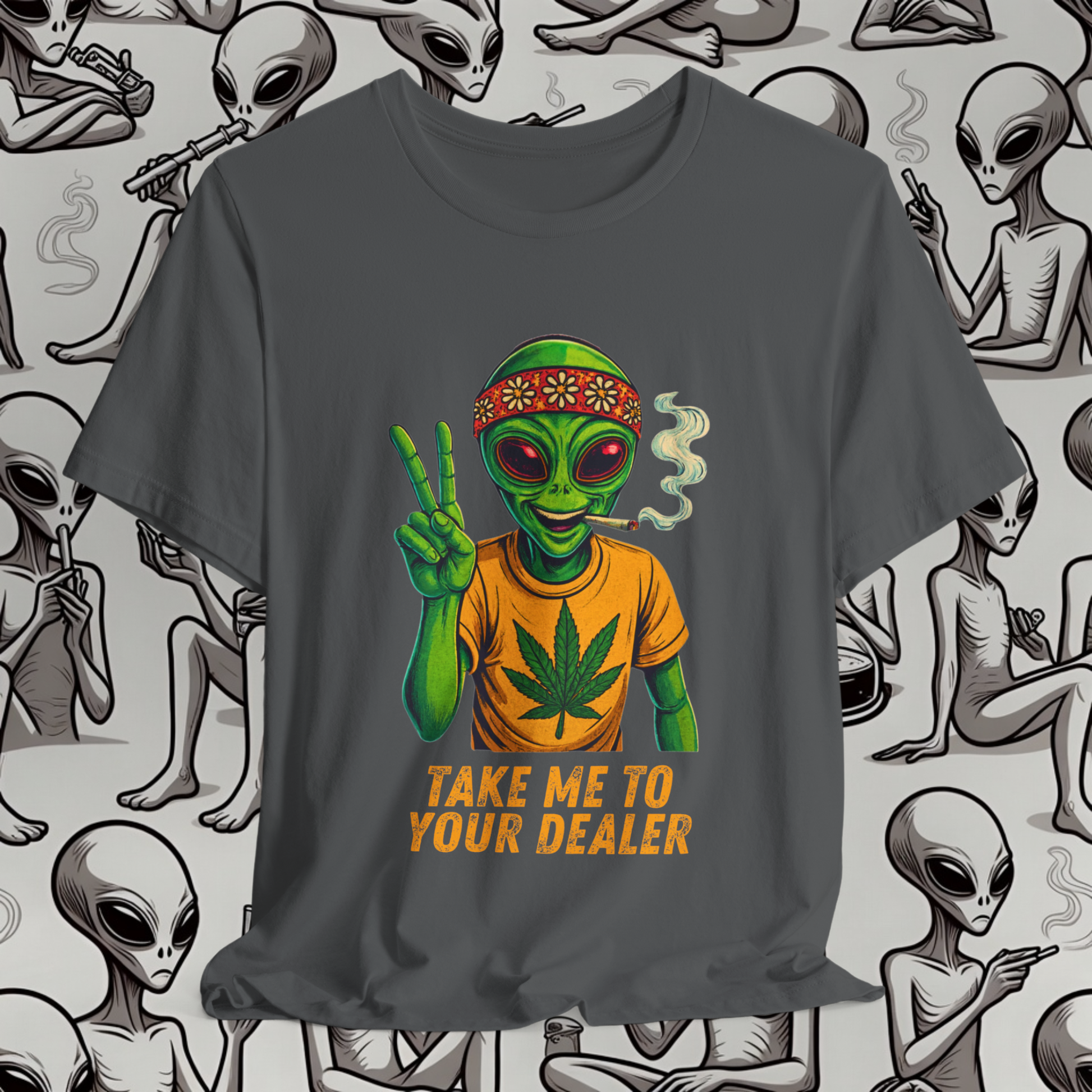 Gray t-shirt with alien graphic and 'Take Me to Your Dealer' text on a background with alien illustrations.