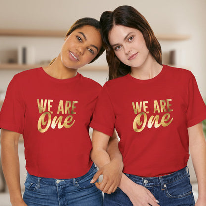 Two people wearing red t-shirts with the text 'WE ARE ONE' in gold